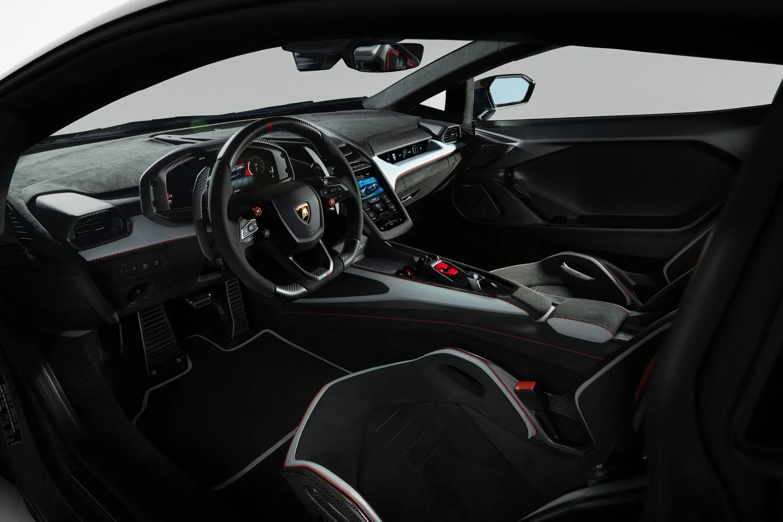 Lamborghini Revuelto SV cockpit interior view showing carbon steering wheel with red anodised drive-mode dial, digital instrument cluster, central touchscreen and Alcantara-trimmed centre console with driver seat visible