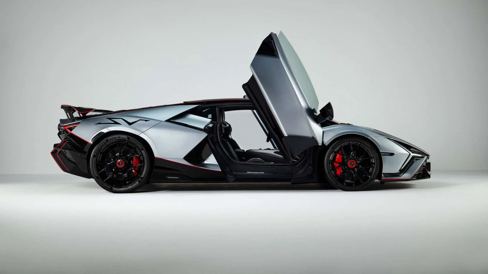 Lamborghini Revuelto SV side profile studio shot with scissor doors open showing the SV nomenclature on flank