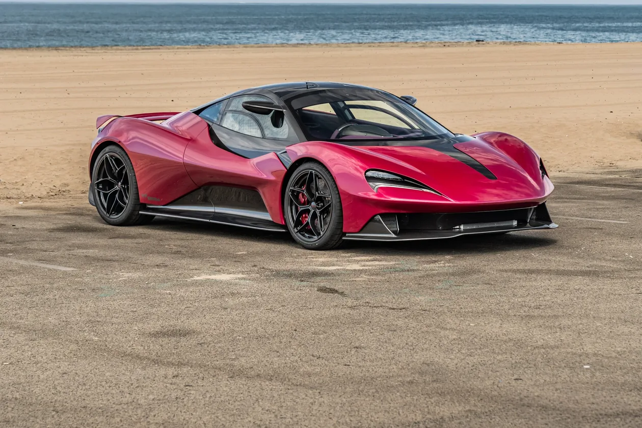 Red Lanzante 95-59 with carbon roof, front three-quarter view on a beach car park
