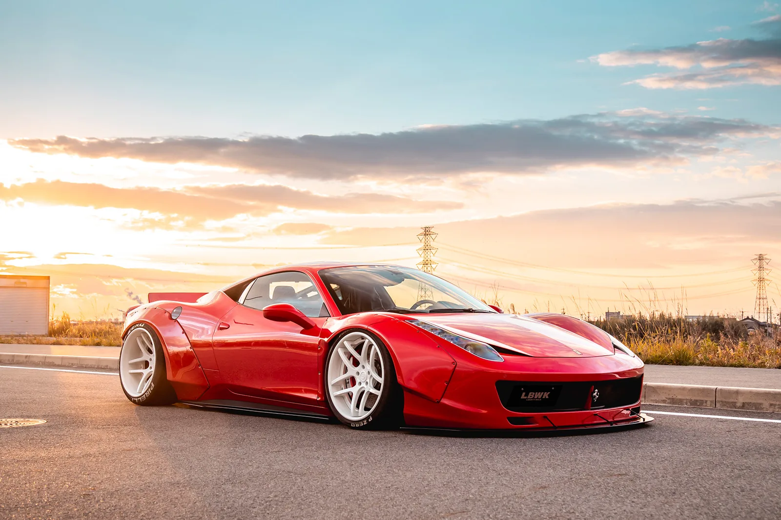 Liberty Walk LB-Works Ferrari 458 in red with wide fenders and forged wheels at sunset