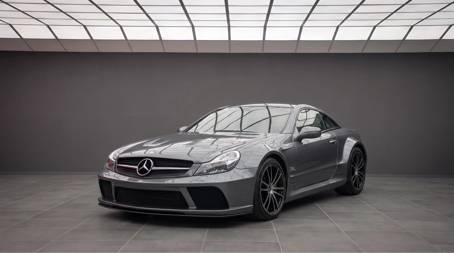 Dark grey Mercedes-Benz SL 65 AMG Black Series in a showroom, front three-quarter view of the only V12 Black Series ever built