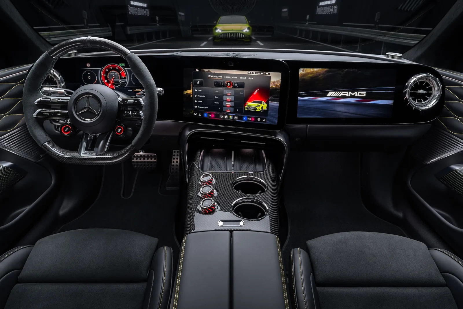 Mercedes-AMG GT 4-Door Coupé EV cockpit — flat-bottom AMG steering wheel with rocker switches, 10.2-inch driver display, 14-inch central touchscreen and dedicated 14-inch passenger display, AMG Race Control Unit with three carbon-fibre rotary dials on the centre console, yellow contrast stitching