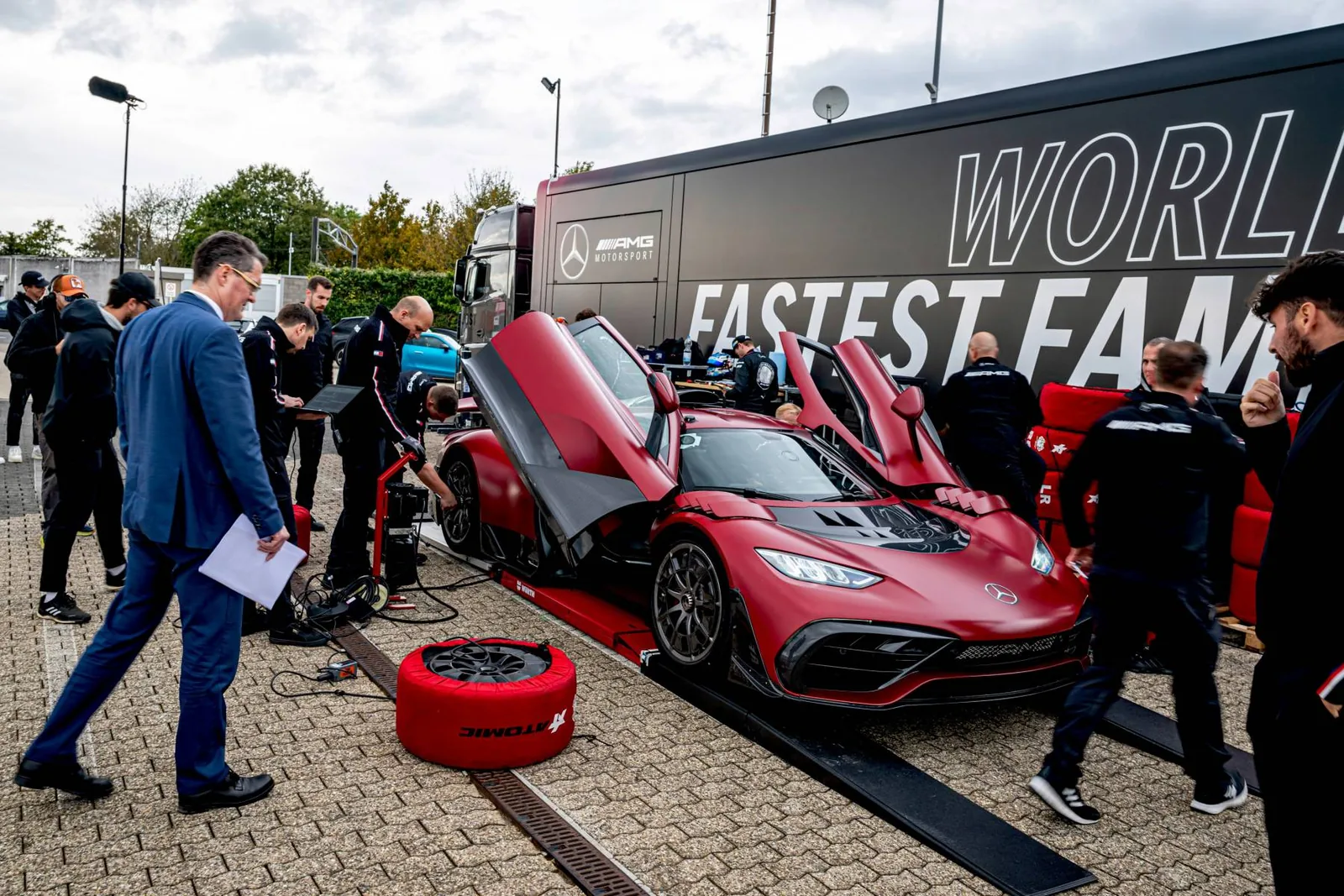 Mercedes-AMG ONE with doors open in the Nürburgring pit lane surrounded by the AMG team