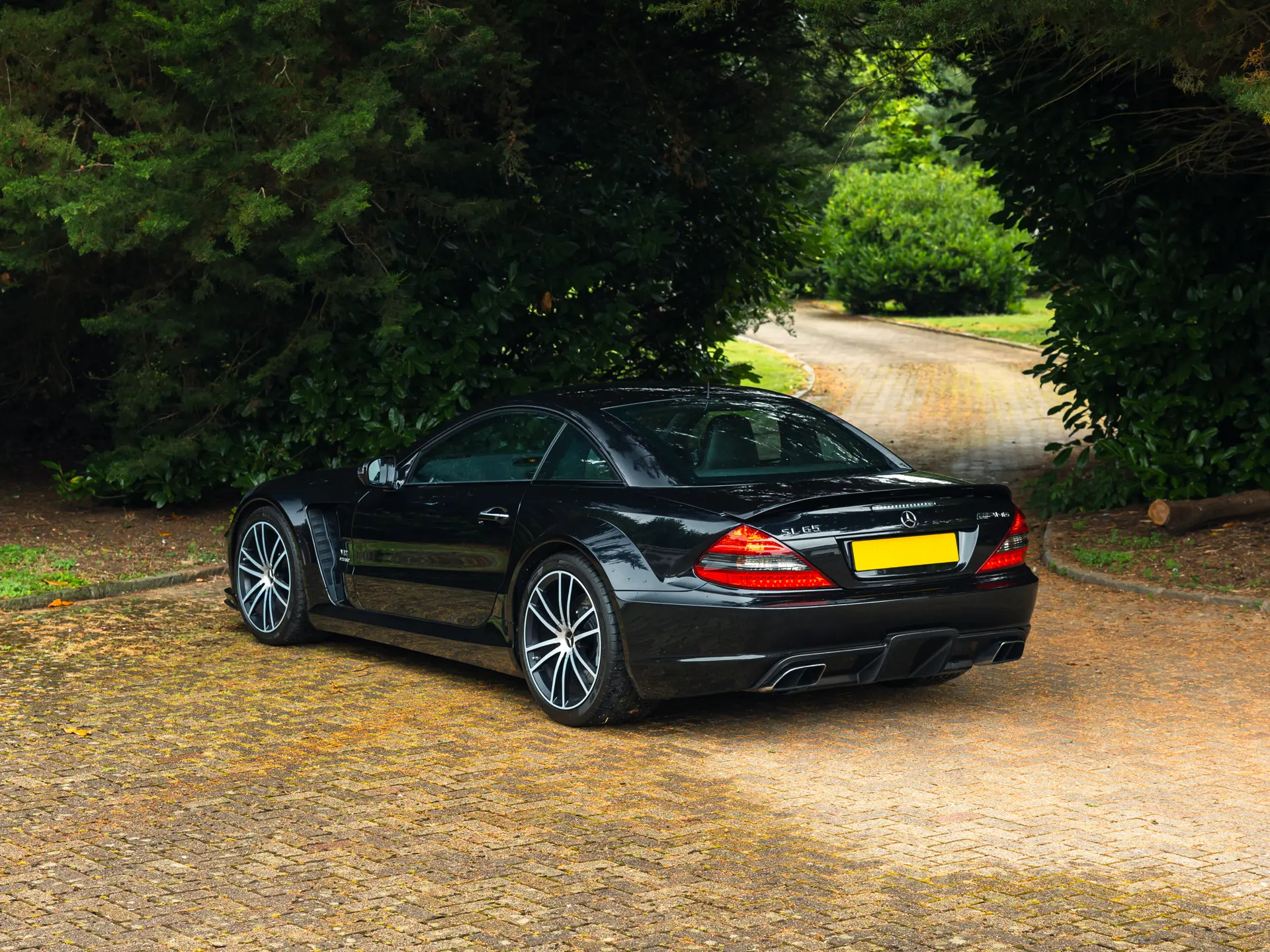 2009 Mercedes SL65 AMG Black Series rear three-quarter — fixed carbon roof, integrated rear spoiler, twin oval AMG tailpipes