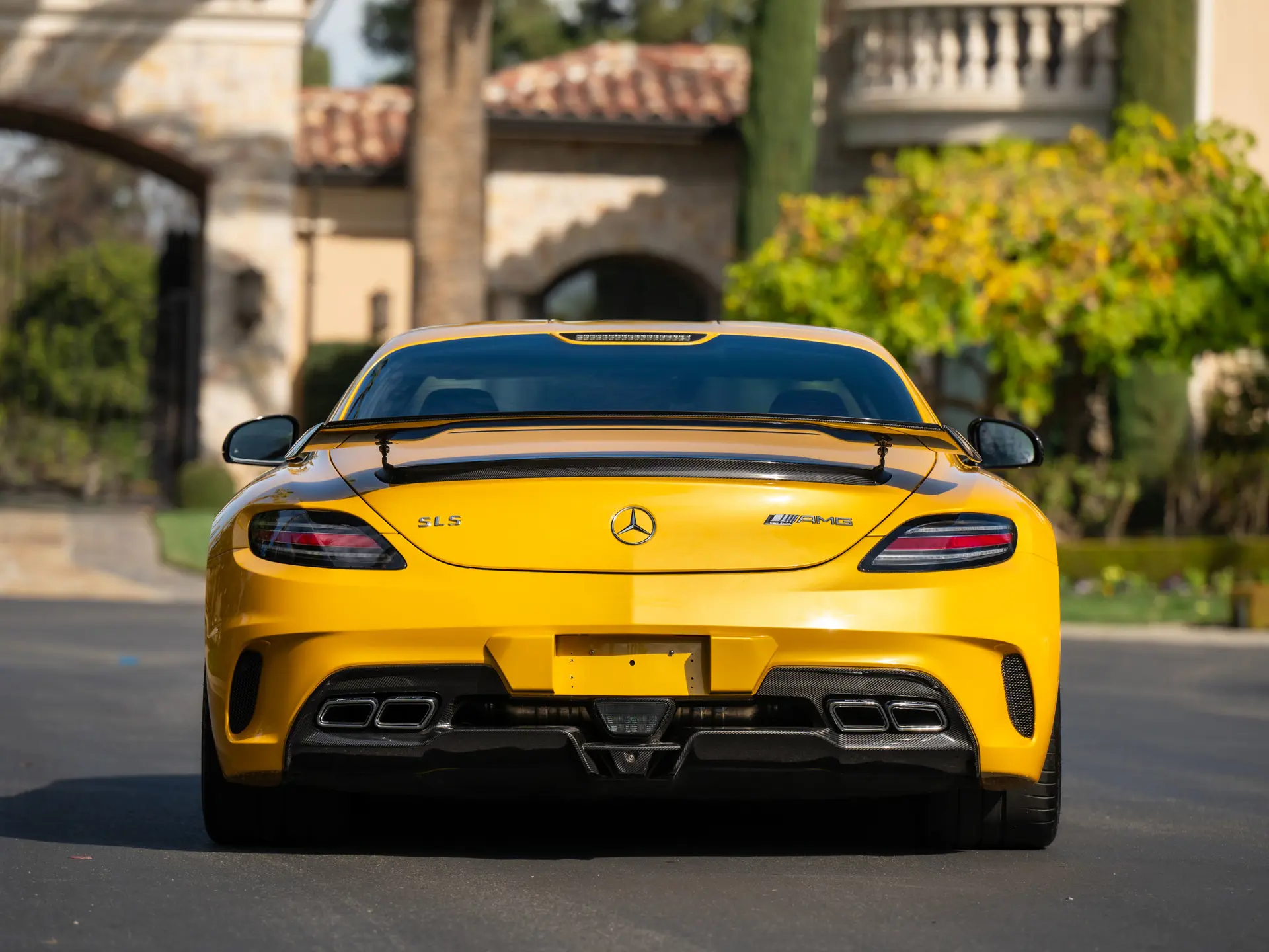 2013 Mercedes SLS AMG Black Series rear head-on in Solar Beam Yellow with fixed GT3-style carbon rear wing and twin AMG exhaust