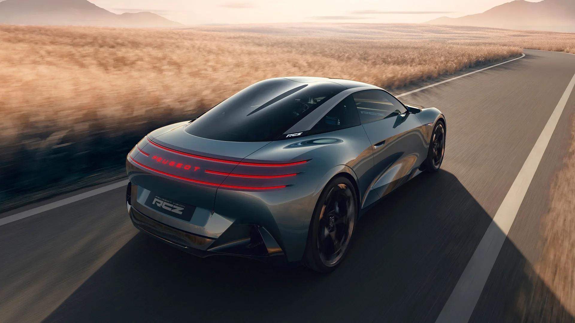 Peugeot RCZ Vision electric coupé from above and behind on a country road, showing the glass double-bubble roof and three-line tail lights