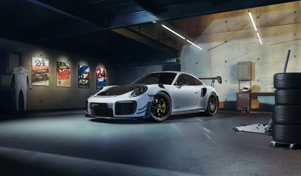 White Porsche 911 GT2 RS of the 991 generation with Manthey performance kit in a garage with racing posters