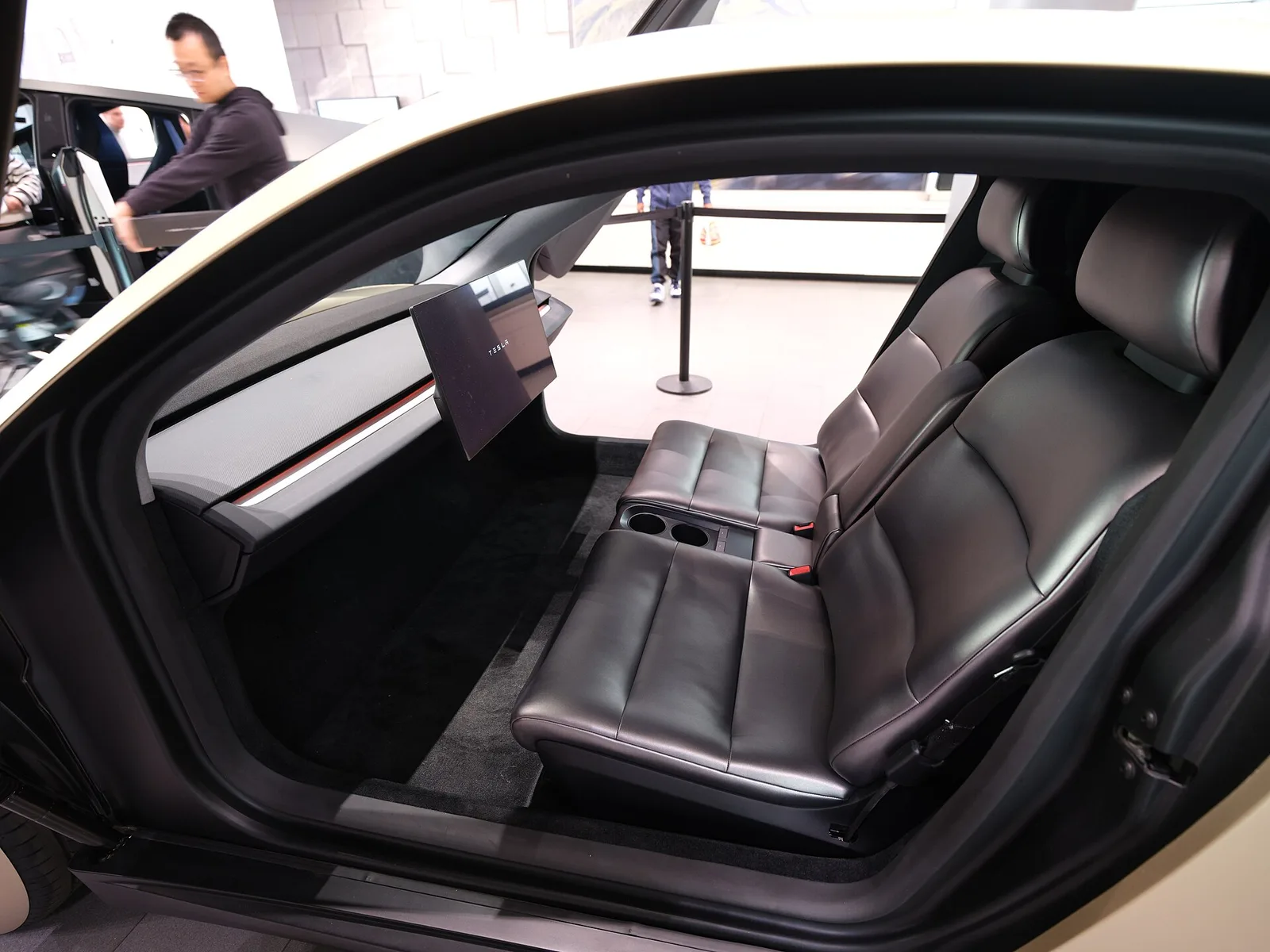 Rear cabin view of the concept Tesla Cybercab on display at Santana Row, showing the bench seat and pivoting screen