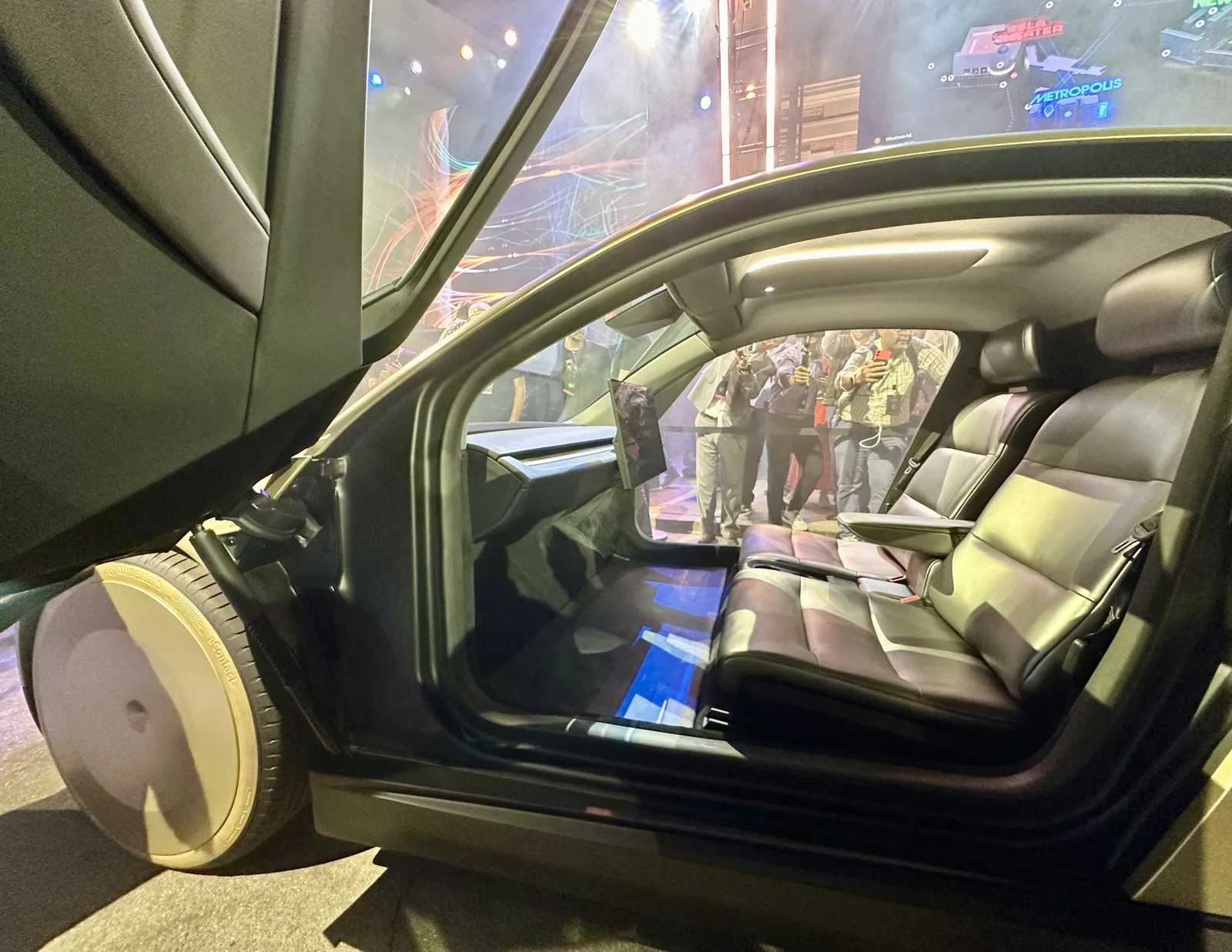Tesla Cybercab two-seat interior with butterfly door open, showing the cabin, seats and low step-in height