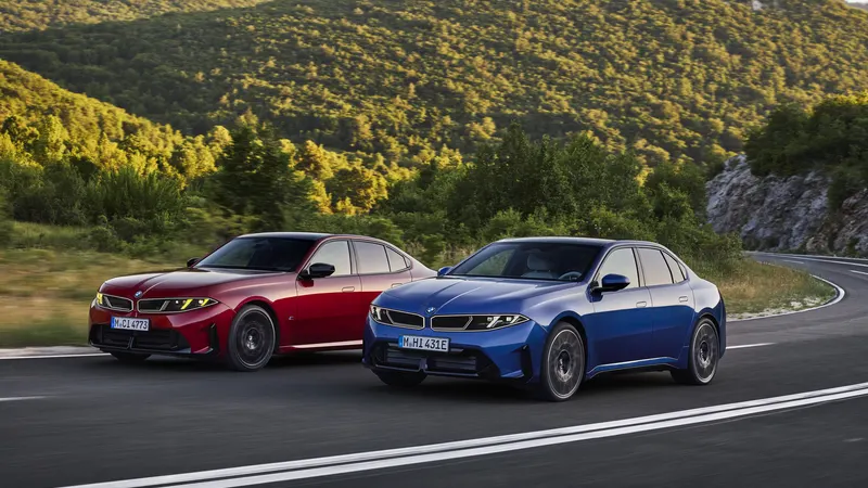 Red and blue new BMW 3 Series G50 sedans driving on a winding mountain road