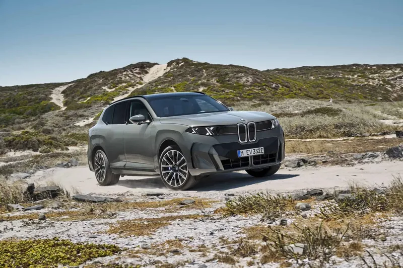 2027 BMW X5 (G65) in sage green on a coastal trail — fifth-generation Neue Klasse SUV with vertical kidney grille